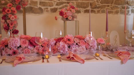 Romantisches-Hochzeitsessen-Mit-Rosa-Blumen,-Goldenem-Besteck,-Kerzen-Und-Pfanne