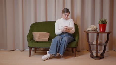 woman sitting on a sofa, working and taking notes