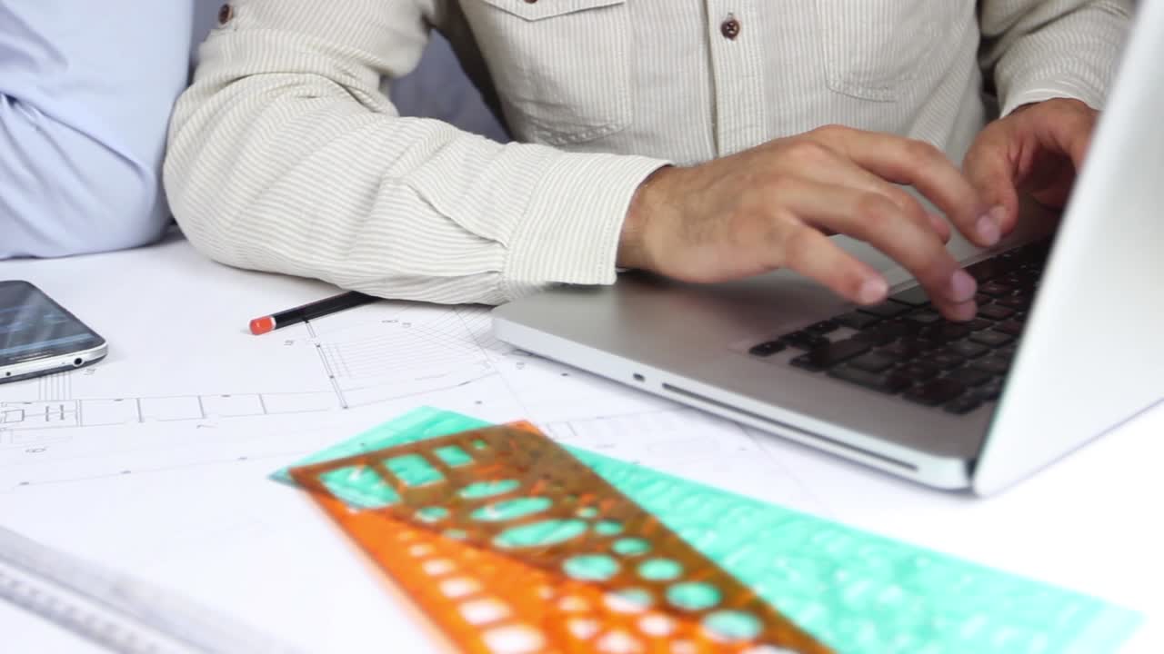 las manos del hombre dibujando líneas en el papel de gran formato en la oficina moderna