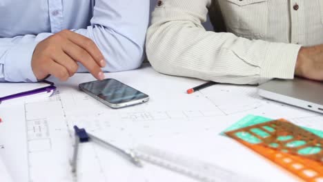 las manos del hombre dibujando líneas en el papel de gran formato en la oficina moderna