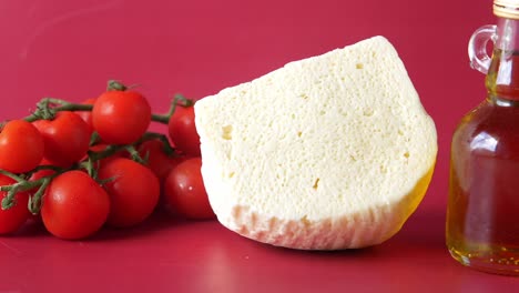 un pedazo de queso blanco con tomates y aceite de oliva
