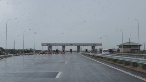 zero traffic at highway toll booth in raining condition driving closer to the exit.