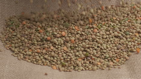 dry lentils legume falling slow motion on jute, organic agriculture, mediterranean food, healthy nutrition