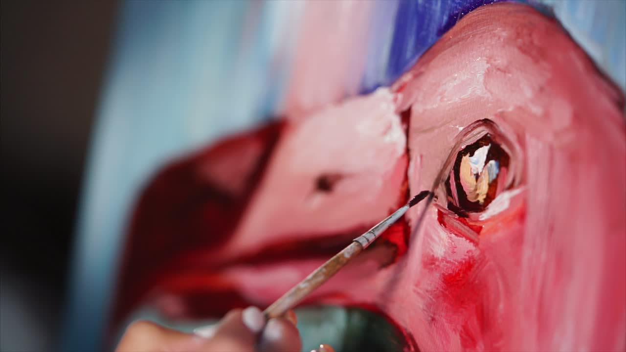 Close-up of an artist painting a flamingo portrait