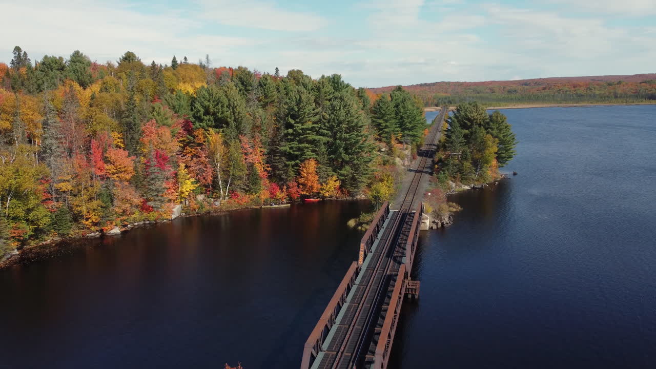 dando vueltas alrededor de un puente ferroviario para revelar más del bosque otoñal y los kayaks