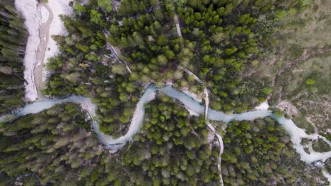 arroyos que contienen sedimentos finos crean un color azul perfecto, como este que fluye de las dolomitas a través de un bosque de pinos