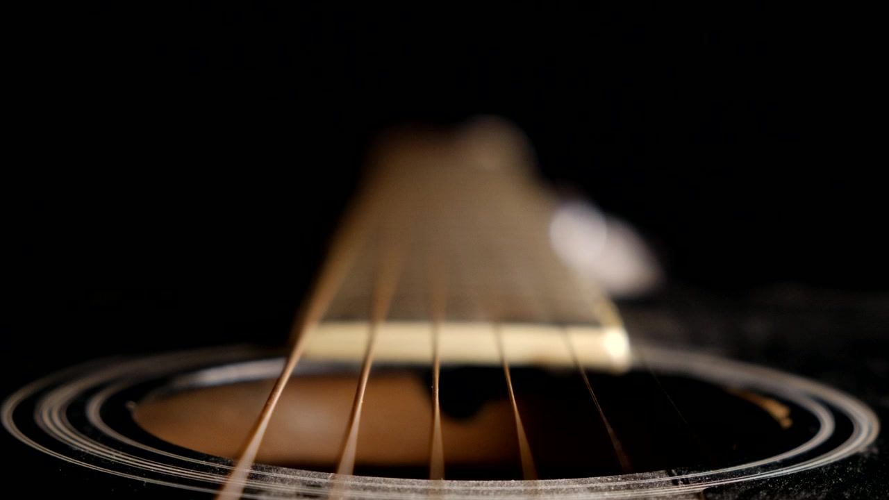 Unique perspective of guitar strings and fretboard of an acoustic guitar