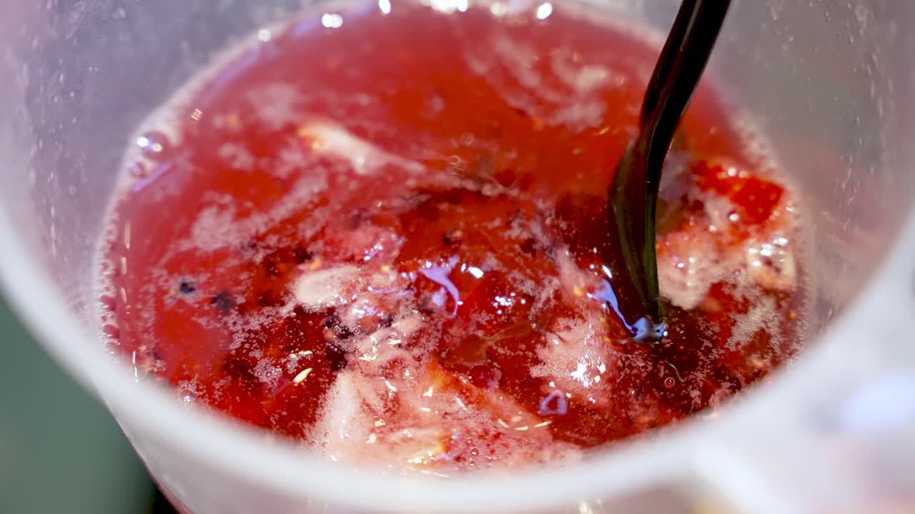 Primo piano di un cocktail di frutta mescolato in una caraffa con fragole e menta. Questa preparazione di bevanda estiva rinfrescante è perfetta per feste ed eventi.