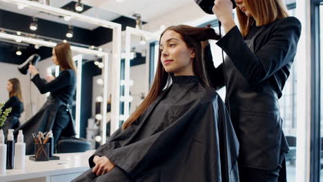 woman getting her hair styled and blow-dried at a modern hair salon