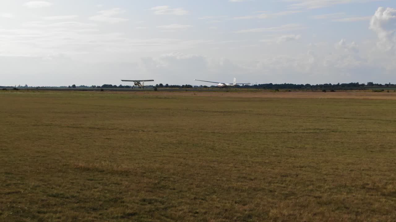 Light Aircraft and Glider Activity on a Grassy Airfield