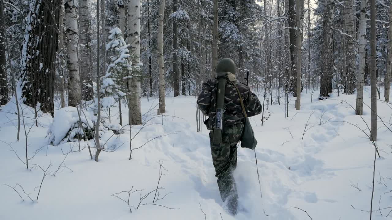 Soldater på vandretur i sneklædt skov