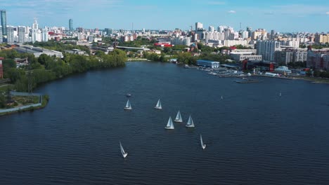 cityscape with sailing boats on a lake