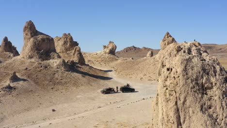 Aerial-4K-shot-of-the-column-of-cars-driving-trough-the-massive-rock-structures