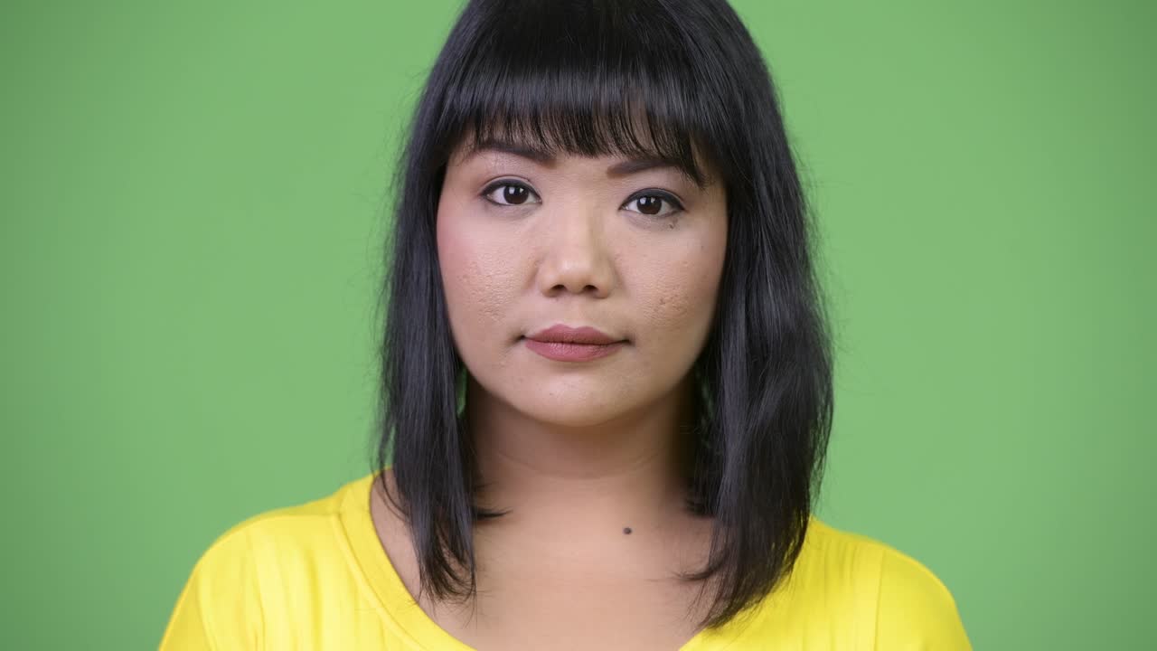 Beautiful Asian woman against green background