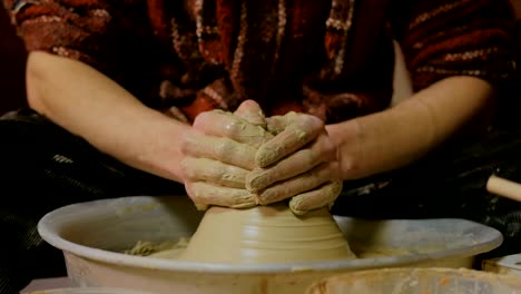 professional male potter working with clay on potter's wheel