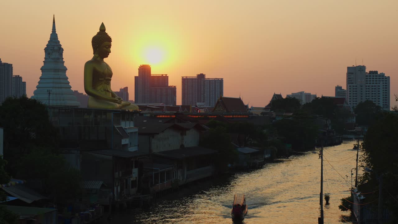 barco de cola larga en un río en bangkok, tailandia con la puesta de sol y el gran buda dorado