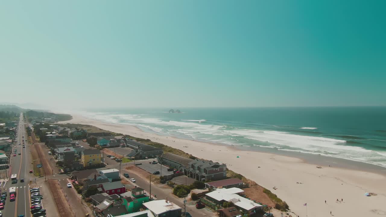 Vista aerea 4K di una città costiera con spiaggia e oceano sullo sfondo.