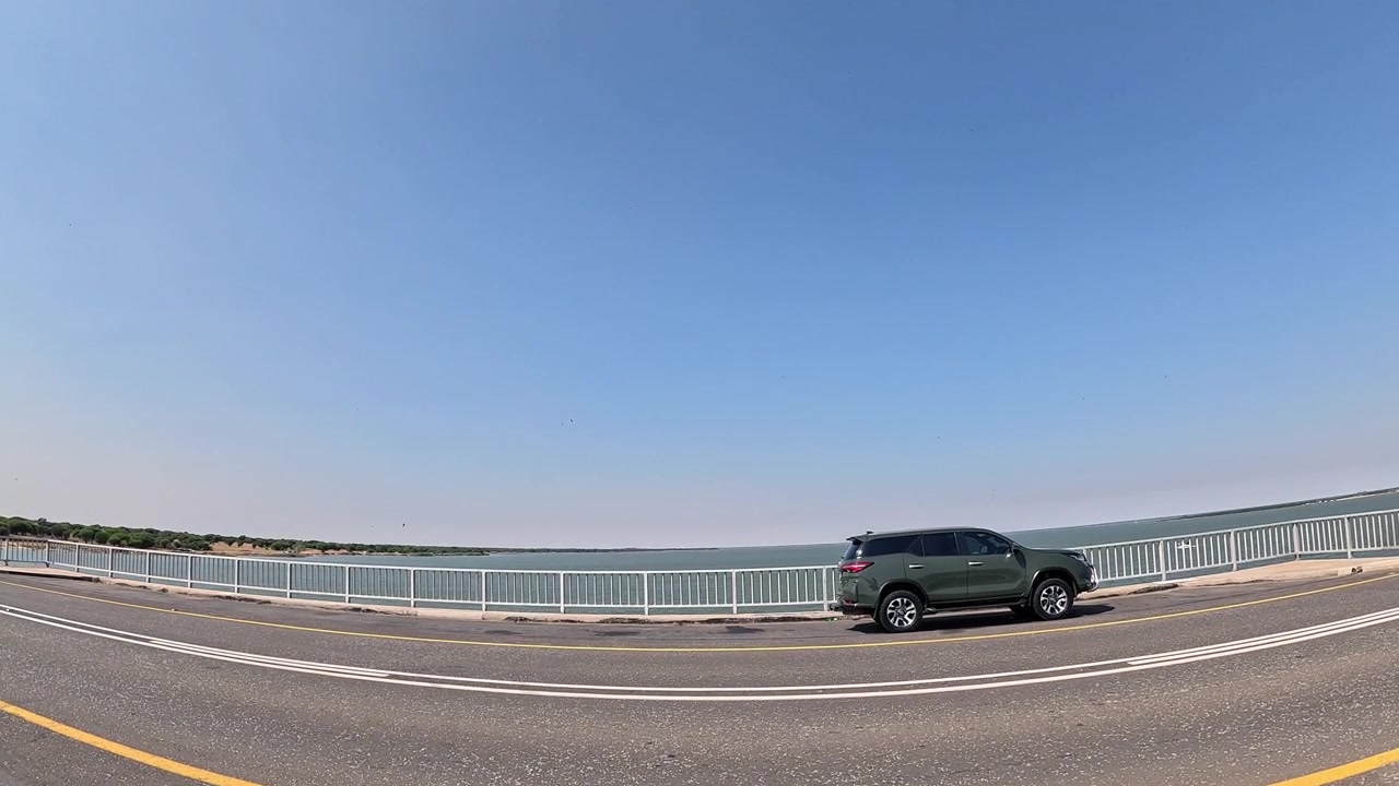 澄み切った青い南アフリカの空の下、ヴァール川の橋を渡る車。