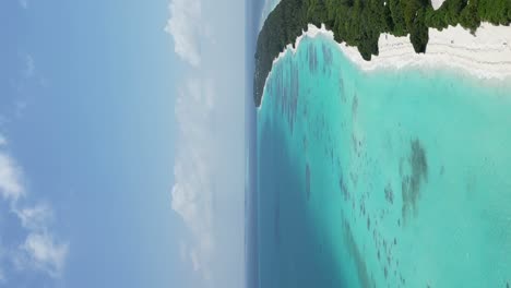 large lagoon of shallow turquoise water surrounding long lush white sand beach of dhigurah island, maldives