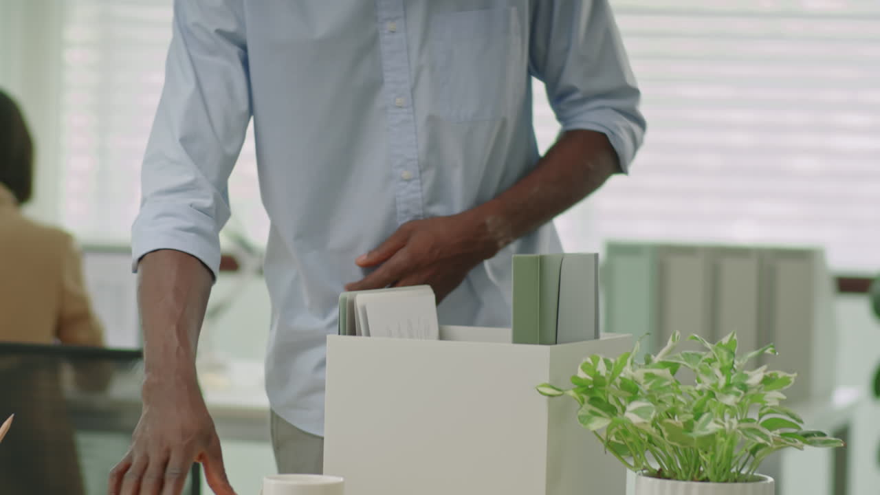 Fired Black Office Worker Packing Stuff into Box