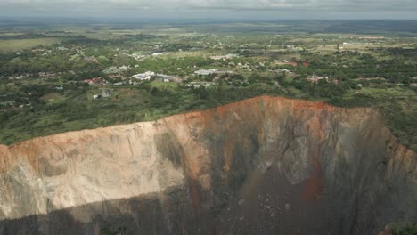 massive abandoned diamond mine open pit with town of cullinan beyond