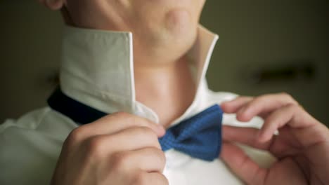 man adjusting bow tie