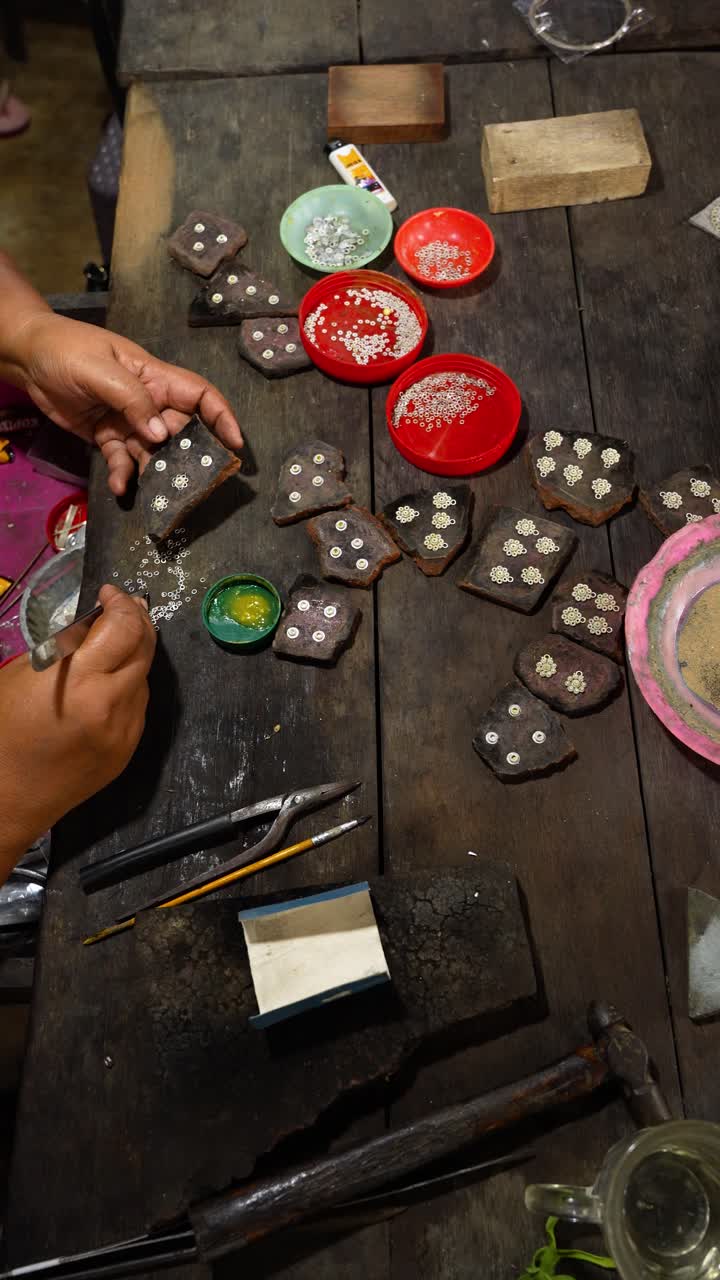 Vertical Shot Of Silversmith Working At Traditional Craft Workshop With Tools On Wooden Table, Celuk Village Bali