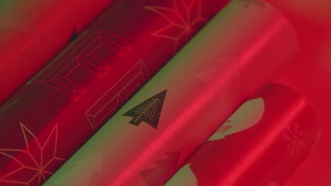 slow motion close-up pan left to right christmas tree logo on wrapping paper roll, vibrant red green two-light