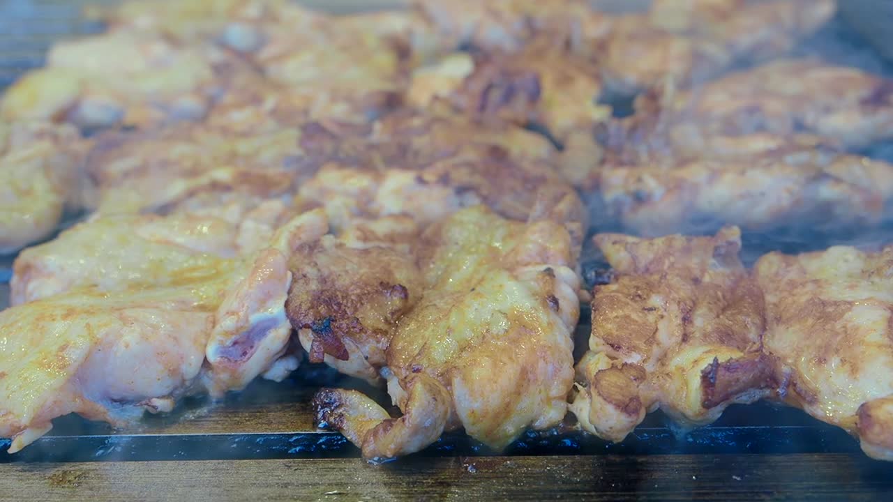 Pollo alla griglia su un barbecue rovente con fumo