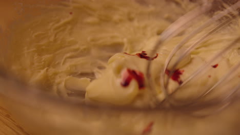 mixing red food coloring into frosting