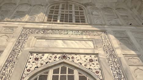 taj mahal facade with arabic calligraphy and plant motifs in agra, india. - low angle shot