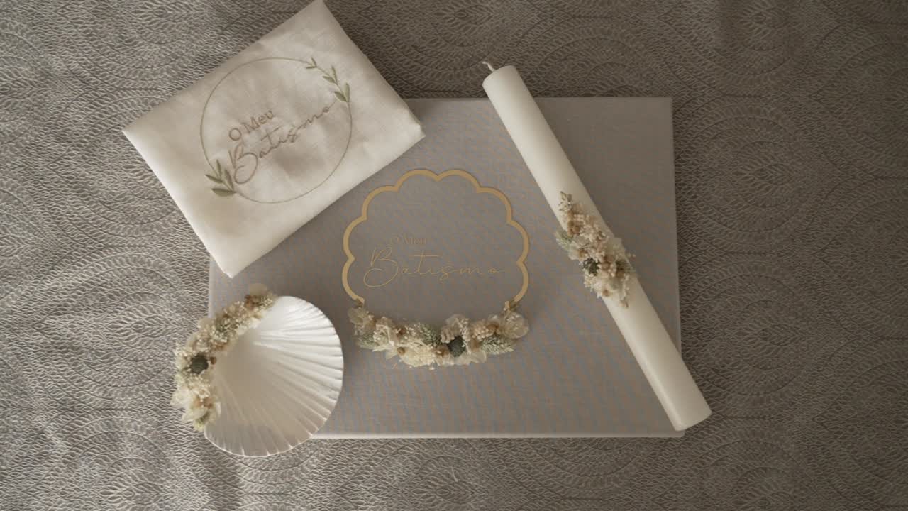 Baptismal candle towel seashell and dried flower items arranged for religious ceremony