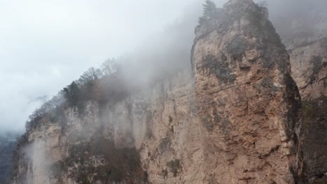 aerial shot of towering rocks enveloped in mist