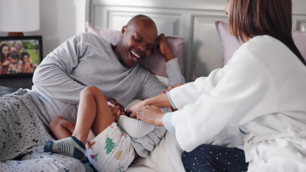 A happy family enjoying playtime in bed