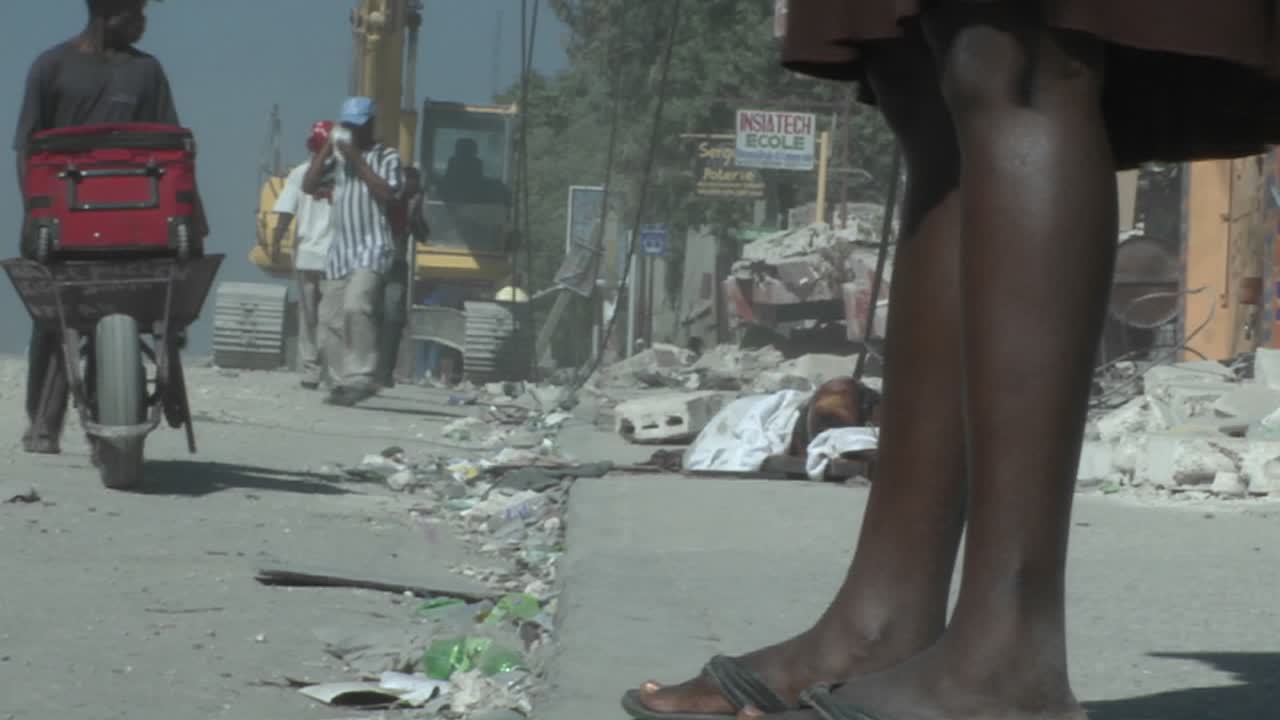 People walk amongst the rubble following a devastating earthquake in Haiti