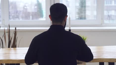 창문 앞 의 테이블 에 앉아 있는 사람