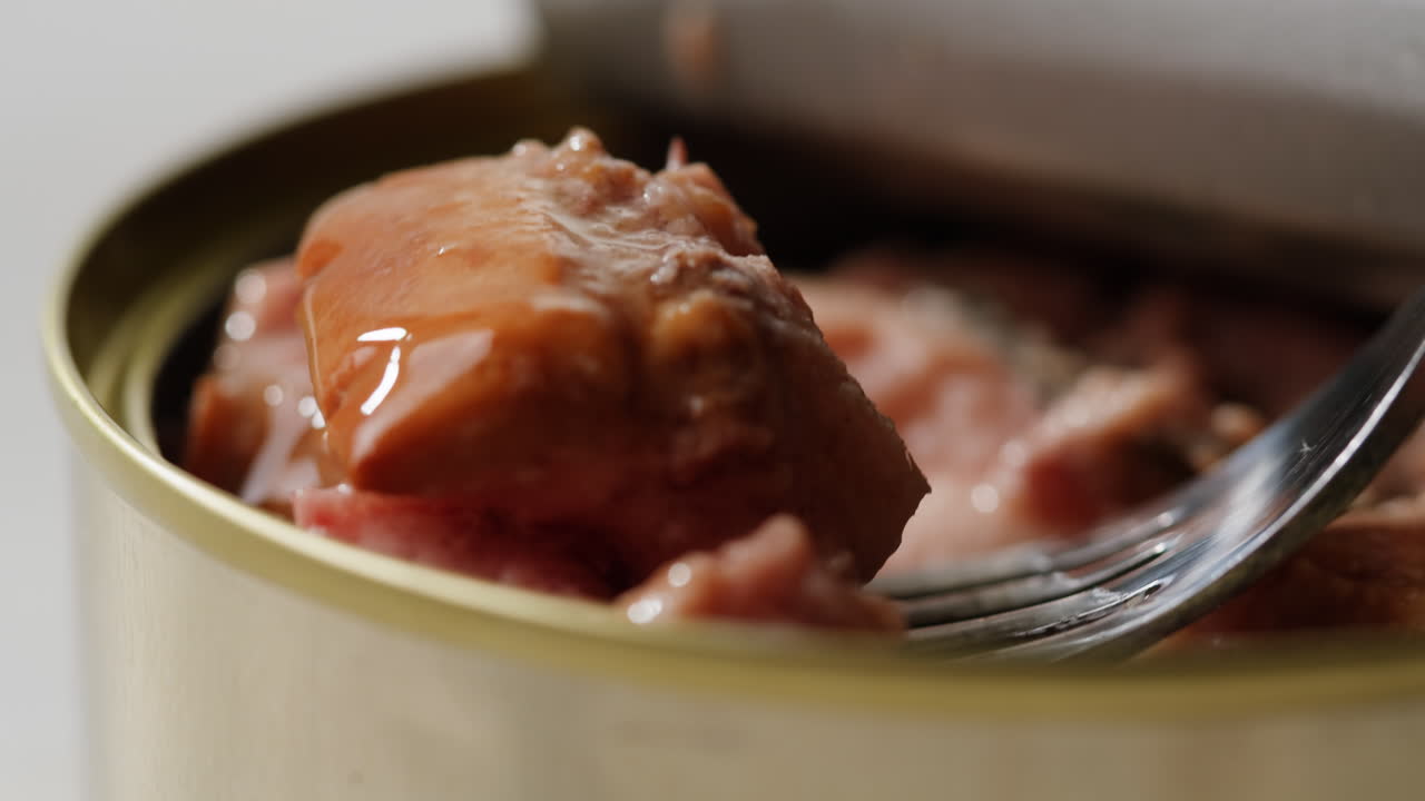 Smoked cod liver in oil in open tin can with fresh greens on wooden table. Seafoods delicacy. High quality 4k footage