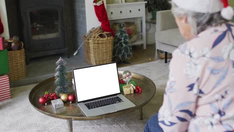 Ältere-Kaukasische-Frau-Mit-Weihnachtsmütze-Macht-Einen-Laptop-Weihnachtsvideoanruf-Und-Kopiert-Platz-Auf-Dem-Bildschirm