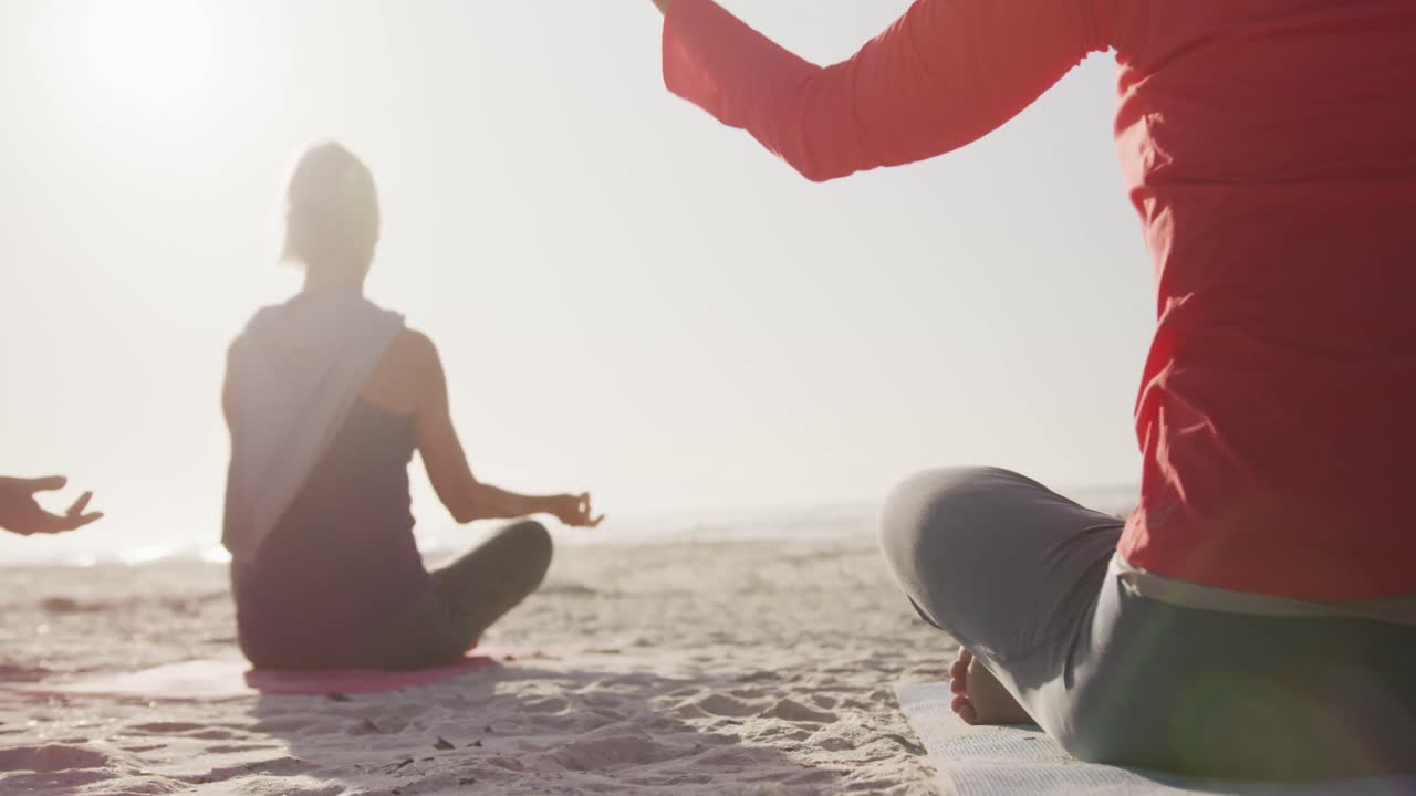 Sahilde yoga yapan atletik kadınlar