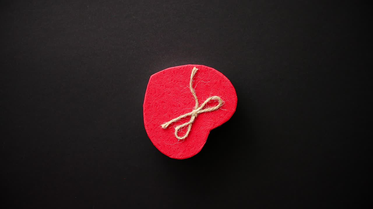 caja de regalo del día de san valentín en forma de corazón en fundamento negro