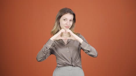 mujer joven mirando a la cámara haciendo una señal de confianza.