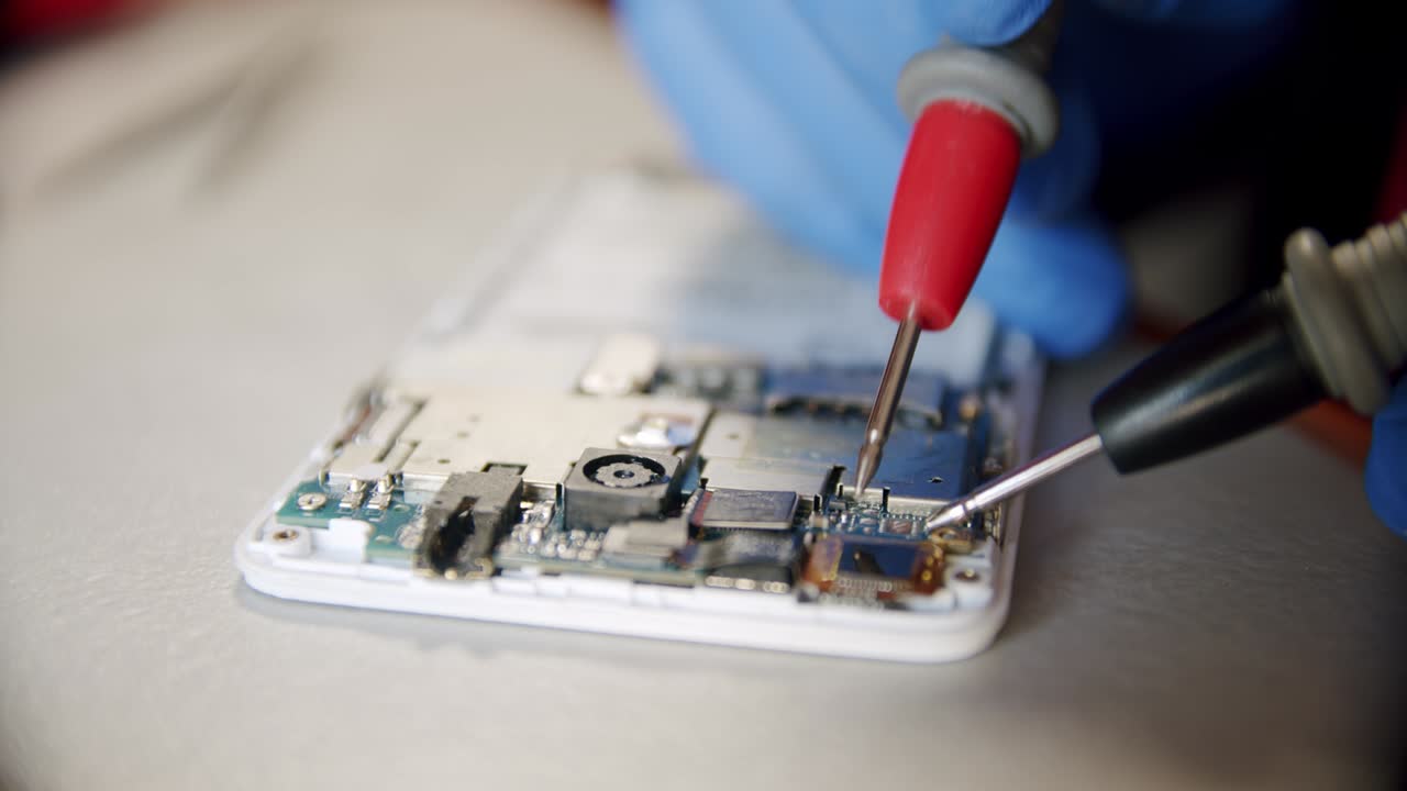 reparador en el servicio de reparación electrónica por medio del probador comprueba la funcionalidad del dispositivo, versión de primer plano 2