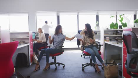 two professional businesswoman discussing over a document in modern office in slow motion