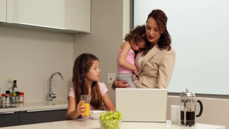 smiling working mother with her children at breakfast