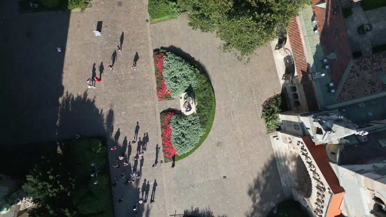 Aerial view of the square and gardens near Ják Chapel with people walking below