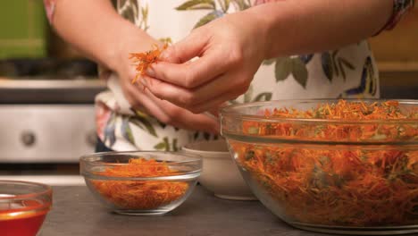 Slow-close-up-dolly-shot-of-a-young-woman-trimming-calendula-medical-flowers-for-a-calendula-beeswax-balsam