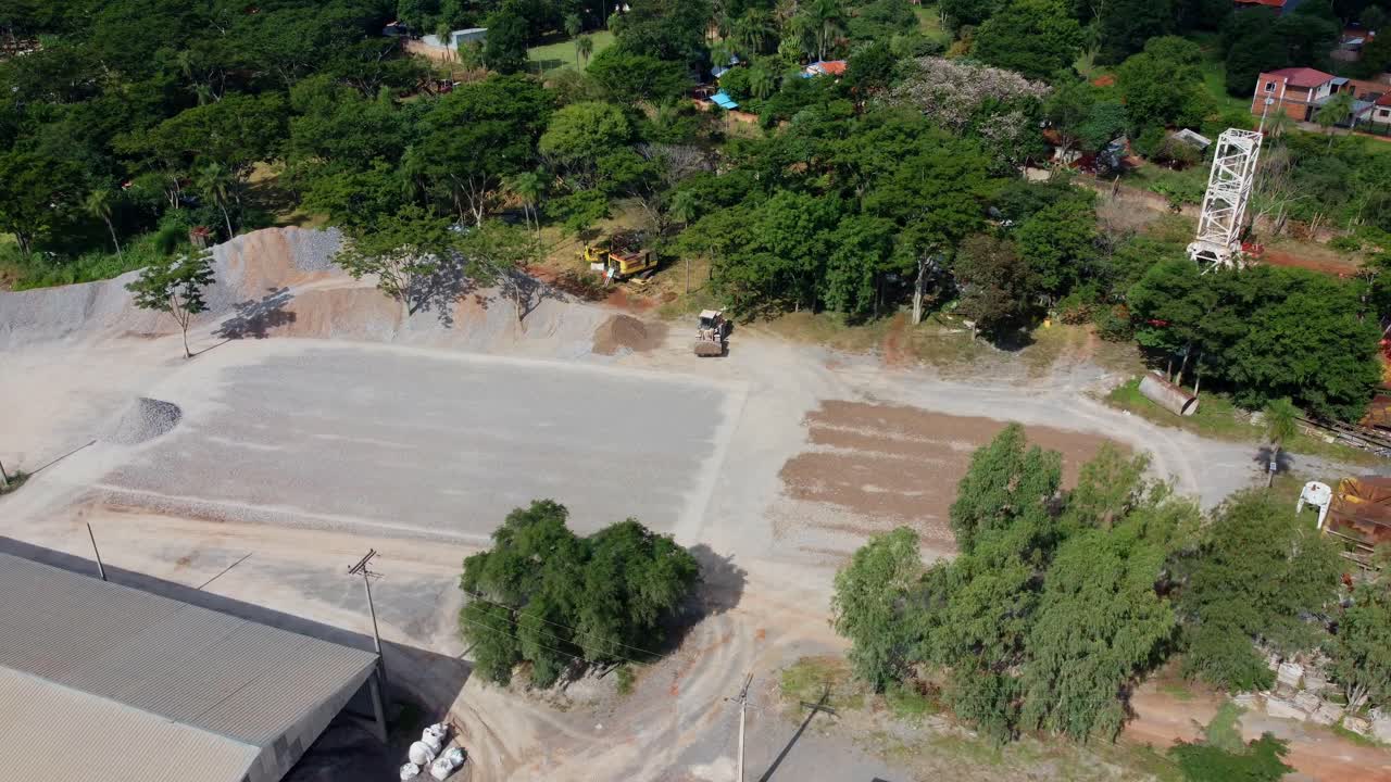 toma aérea de la excavadora excavadora amarilla extrayendo del montón de suelo, campo de construcción