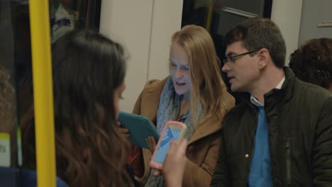 commuters using pad and cell in metro train