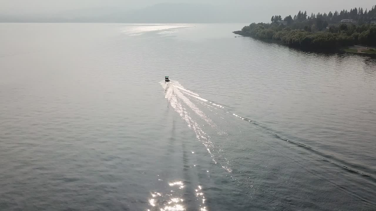 연어 팔 브리티시 컬럼비아 캐나다에 의해 슈슈왑 호수를 가로질러 순항하는 모터 보트의 공중 드론 샷