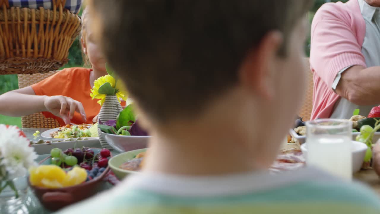 夏に屋外で一緒に食事をする家族